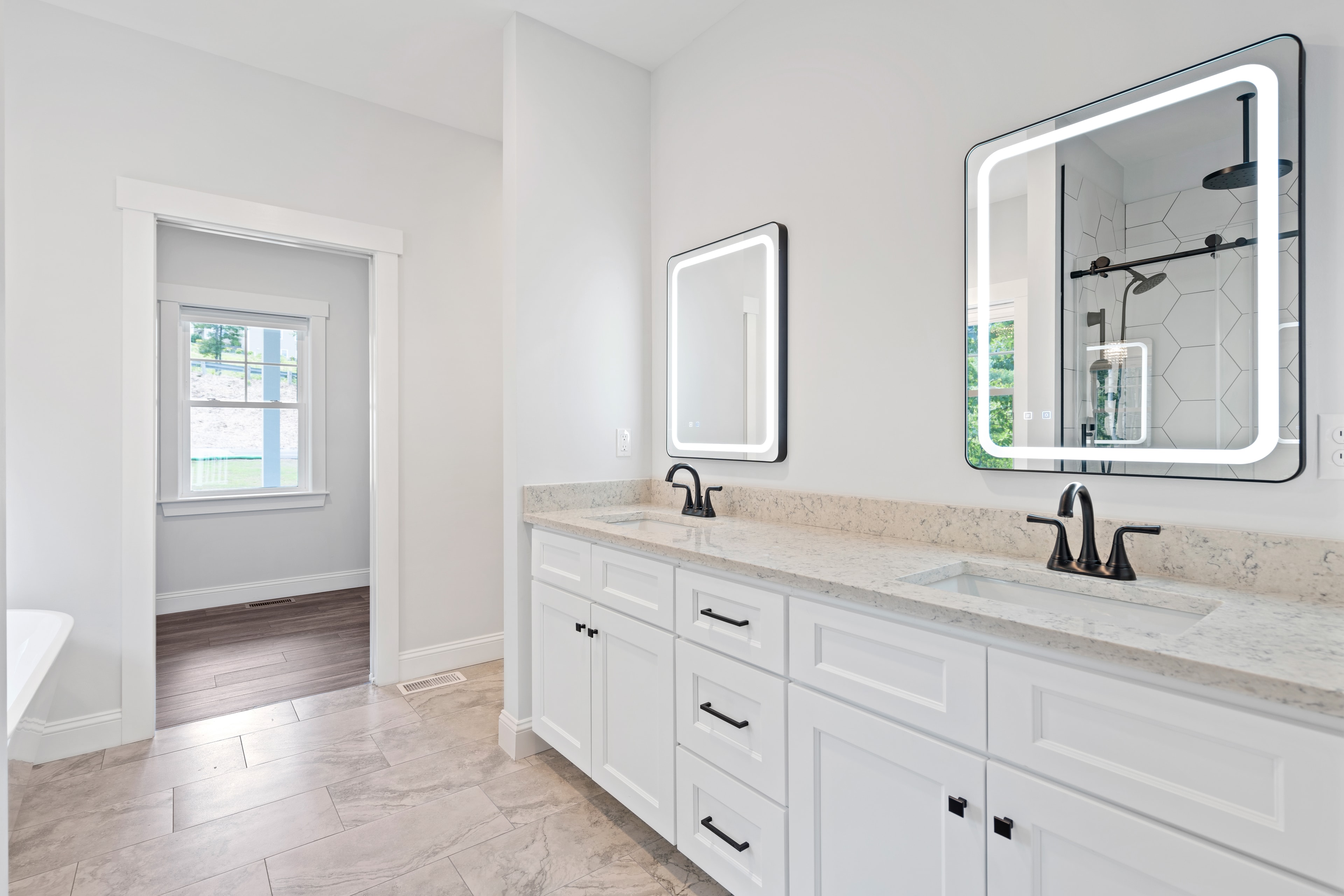 Clover Ridge Home master bath with dual-sink white shaker vanity, quartz countertop, LED mirrors, and black hardware — Meredith, NH