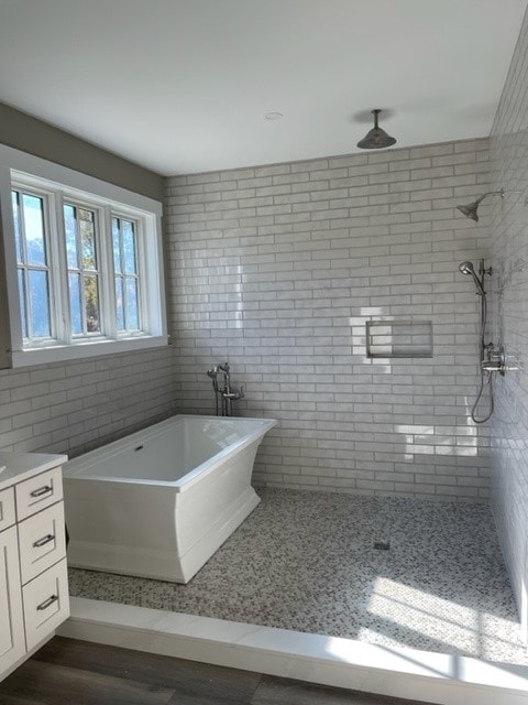Custom New Build master bath with freestanding soaking tub, subway tile walls, pebble tile floor, and rain shower — Bedford, NH