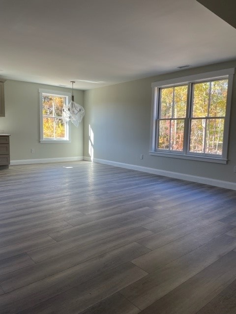 Custom New Build open dining and living area with wide-plank floors, large windows, and autumn foliage views — Bedford, NH