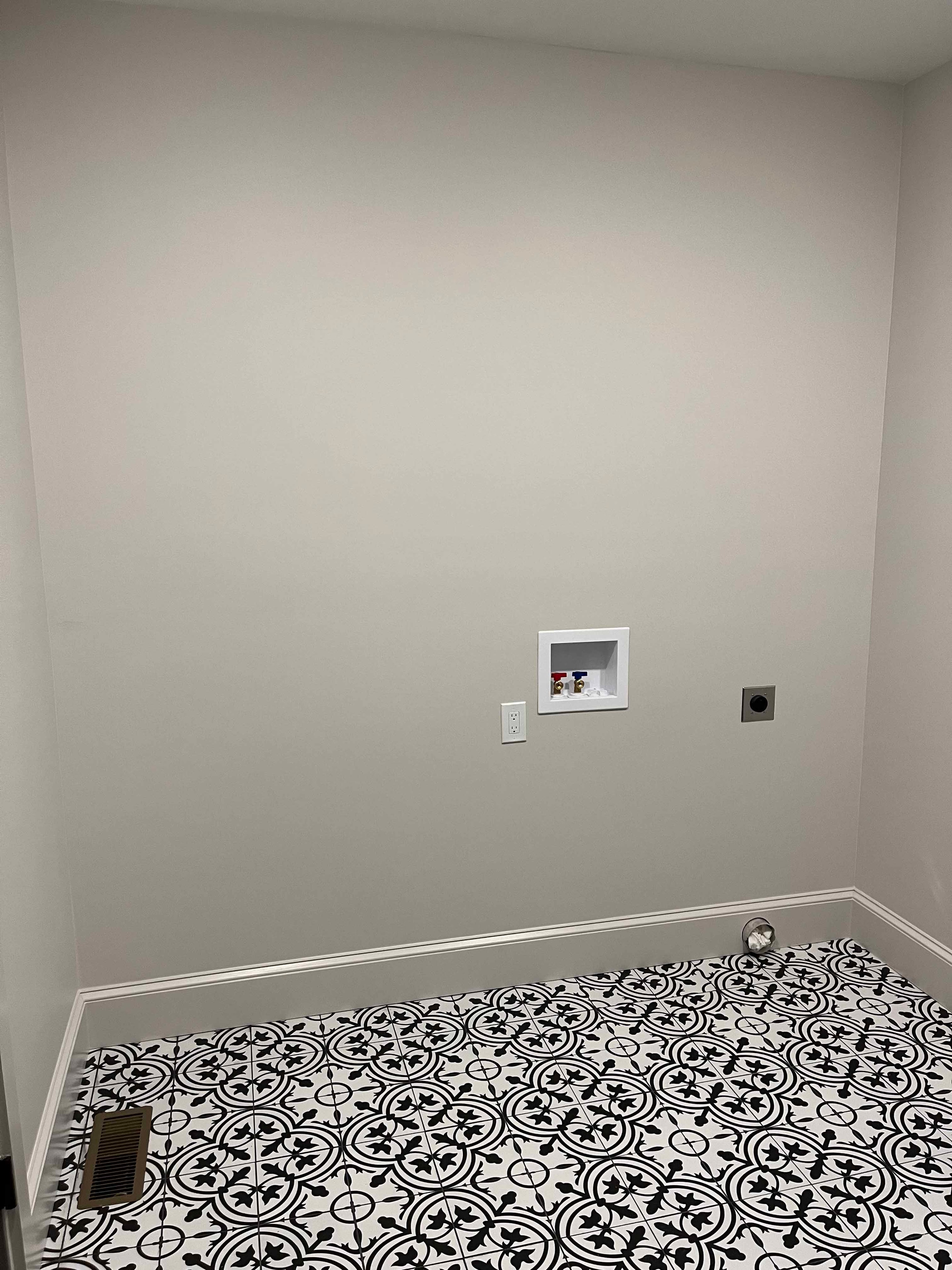 Holderness Home laundry room with black-and-white patterned tile floor and washer hookup