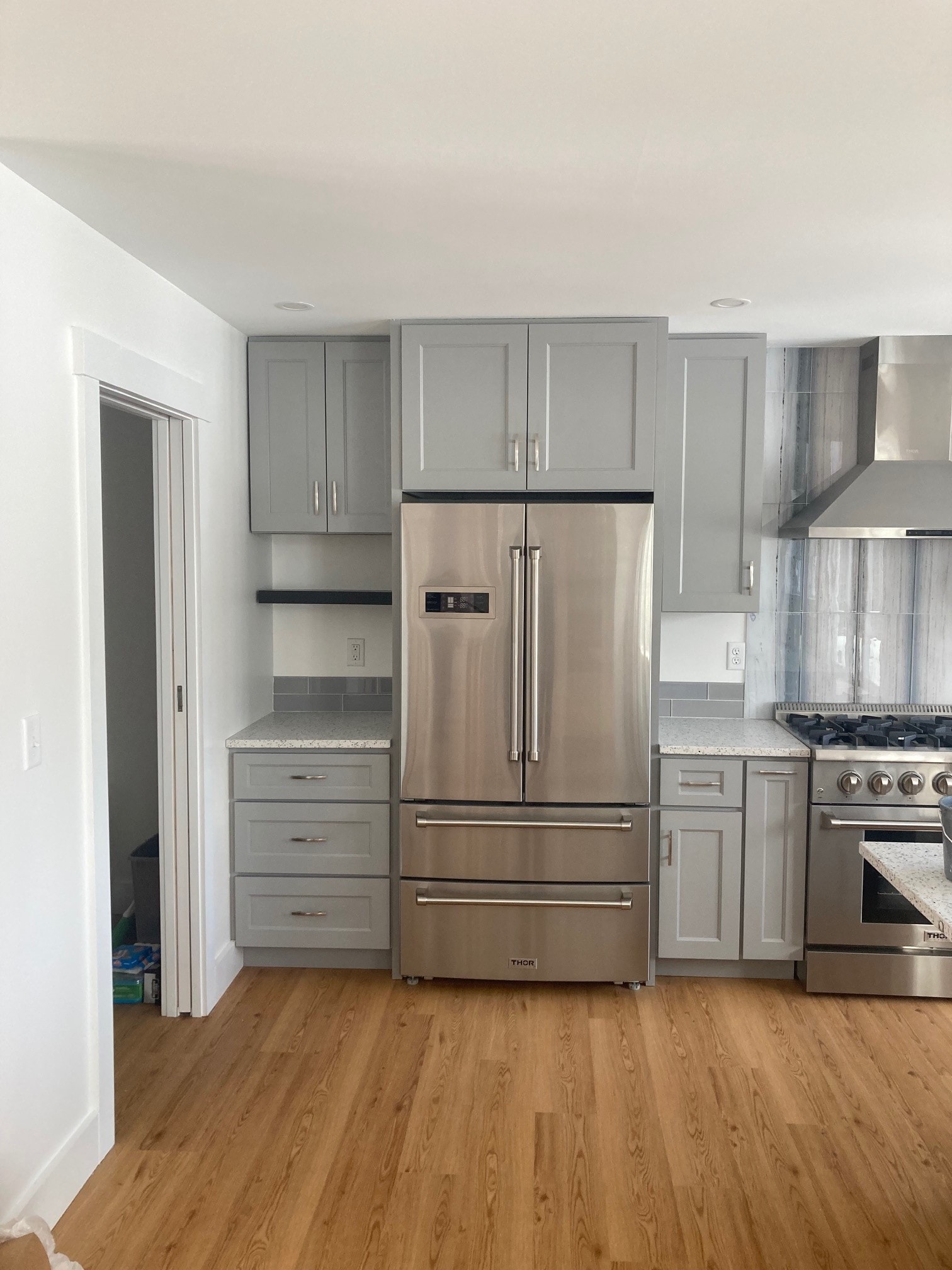 Lake Kanasatka Home kitchen showing Thor French-door refrigerator, gray shaker cabinets, quartz countertops, and gas range — Moultonborough, NH