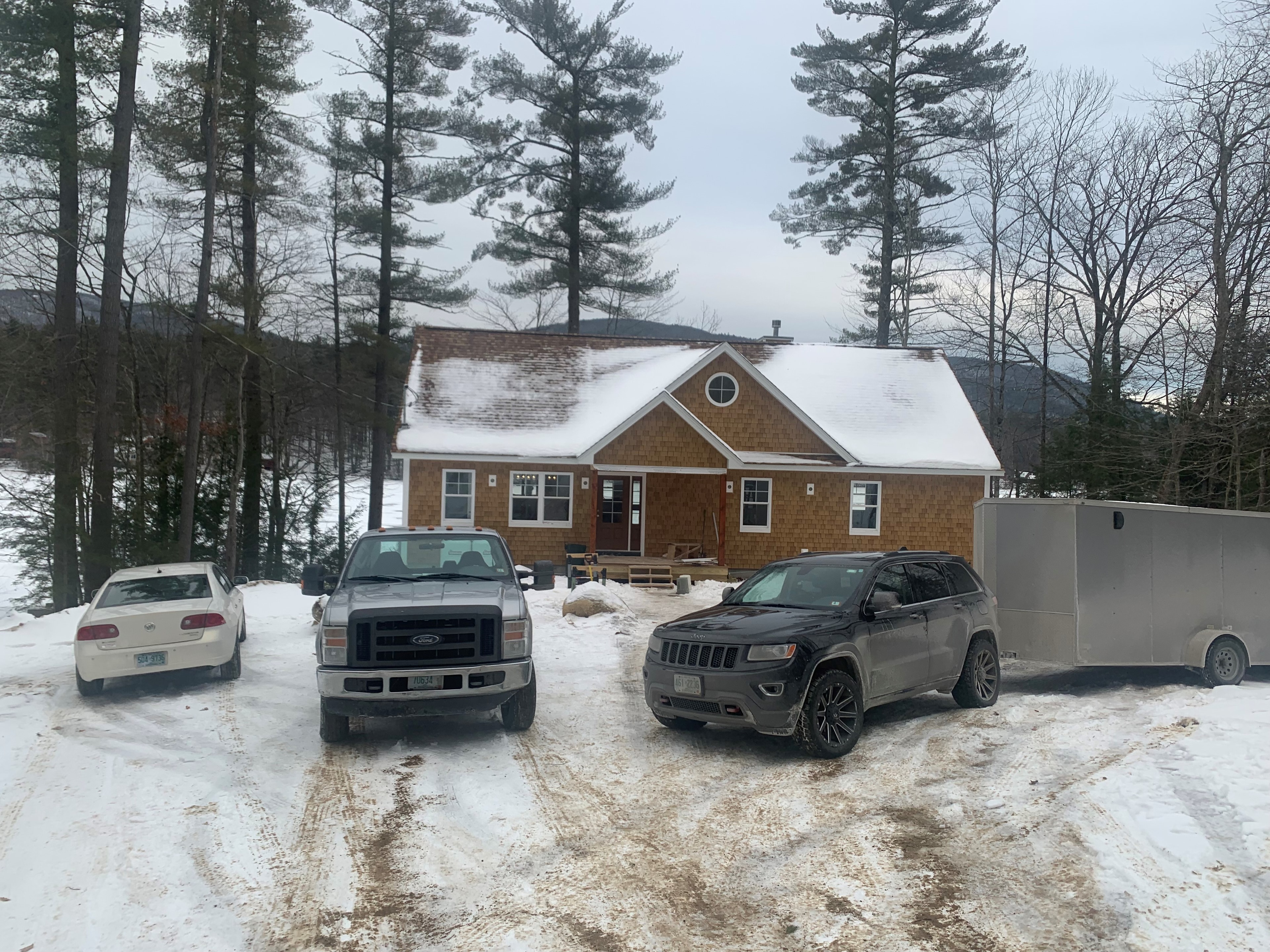 Lake Kanasatka Home cedar shake exterior under construction in winter with lake and mountain views — Moultonborough, NH