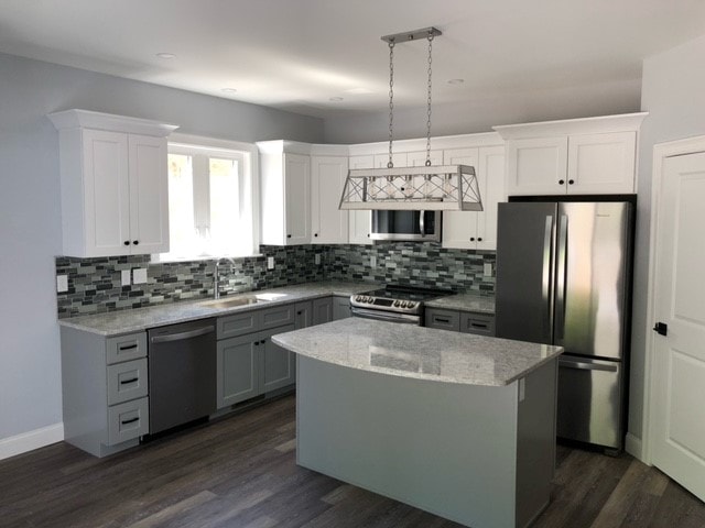 Mason New Build kitchen with white upper and gray lower shaker cabinets, granite island, mosaic tile backsplash, stainless appliances, and lantern pendant — Governor's Crossing, NH
