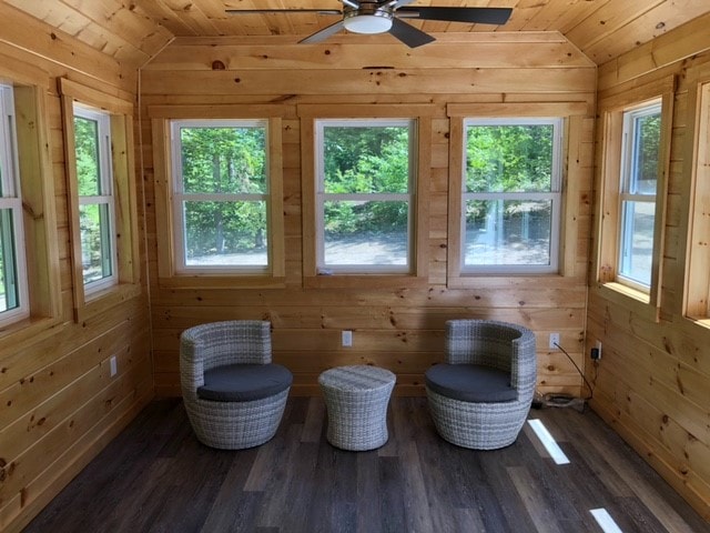 Mason New Build knotty pine sunroom with vaulted ceiling, ceiling fan, three windows overlooking wooded yard, and wicker furniture — Governor's Crossing, NH