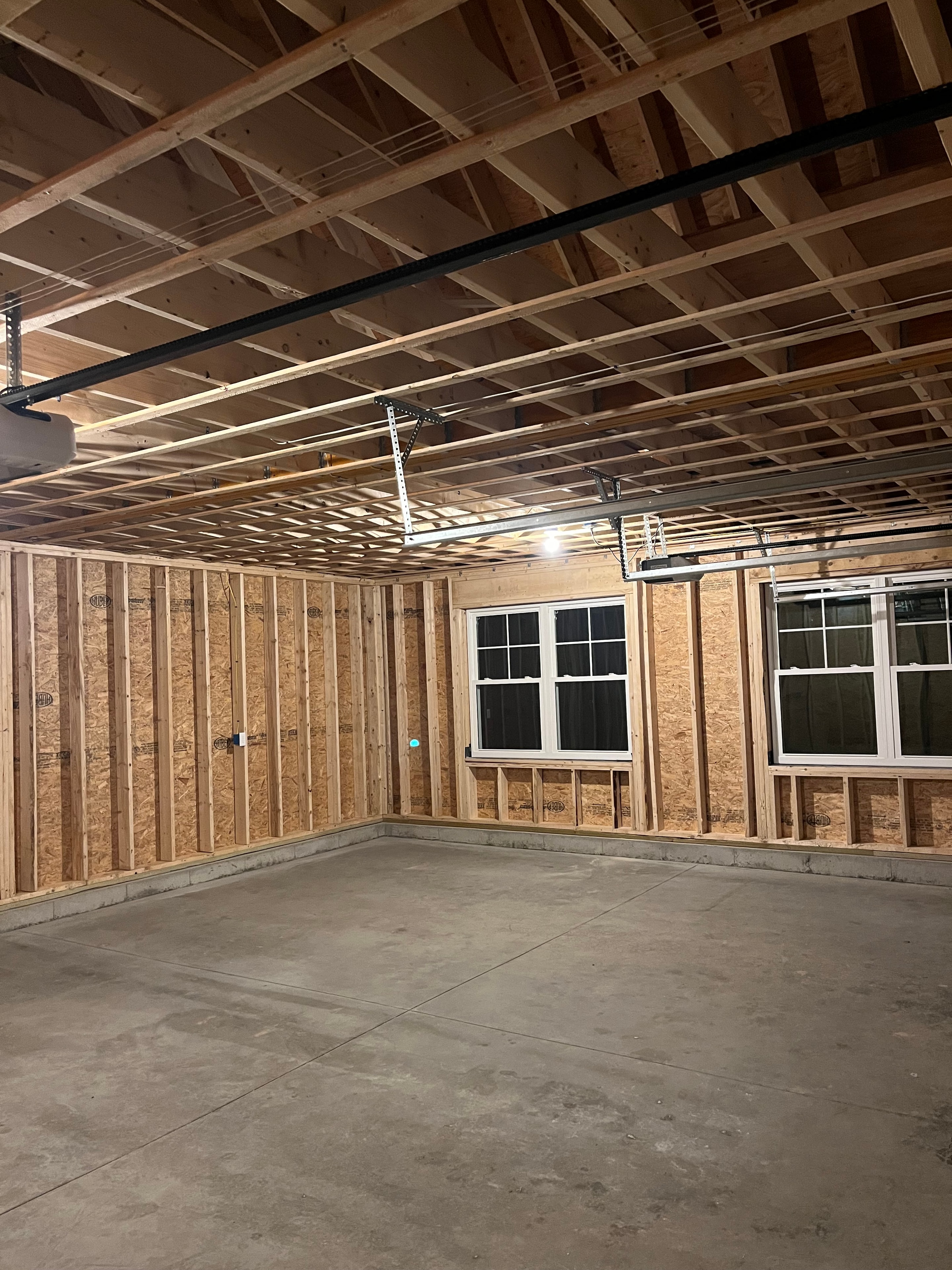 Mountain View Home framing stage interior showing floor joists, stud walls, windows, and concrete foundation