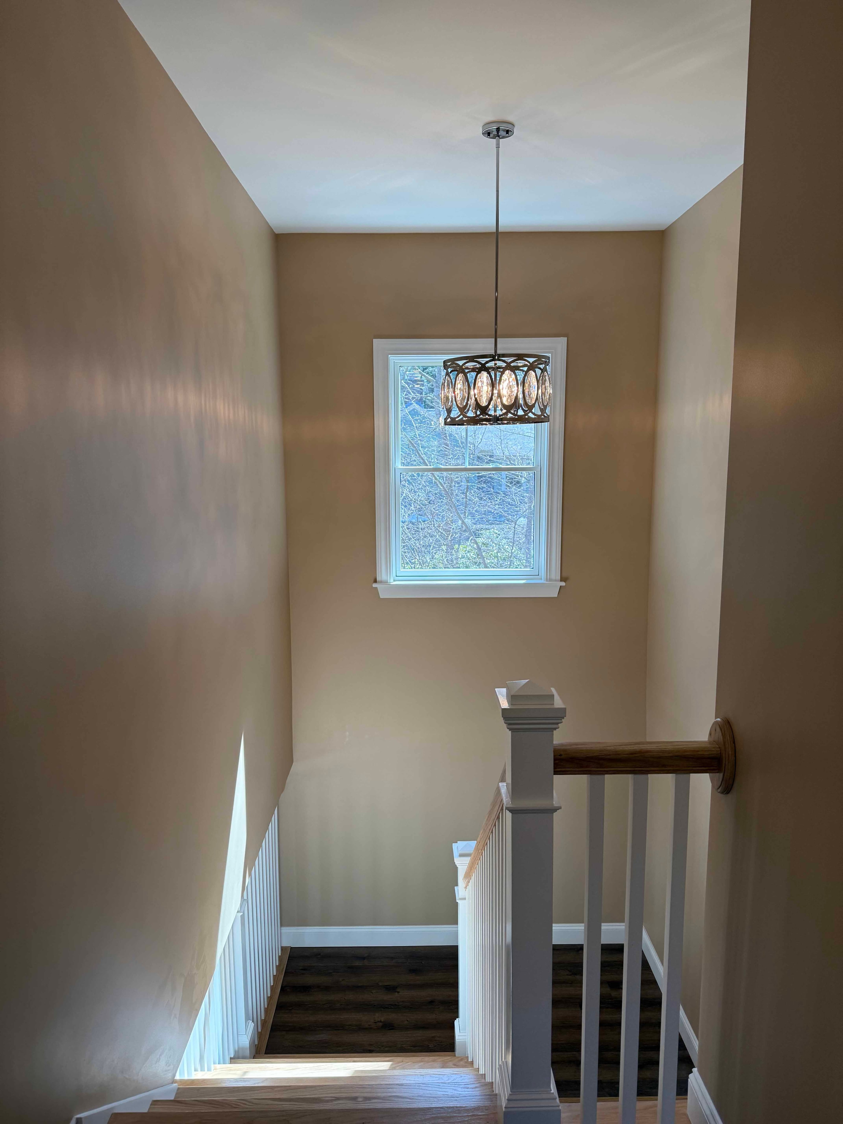 Squam Lake Home upper bedroom with yellow walls, vaulted ceiling, and dark hardwood floors