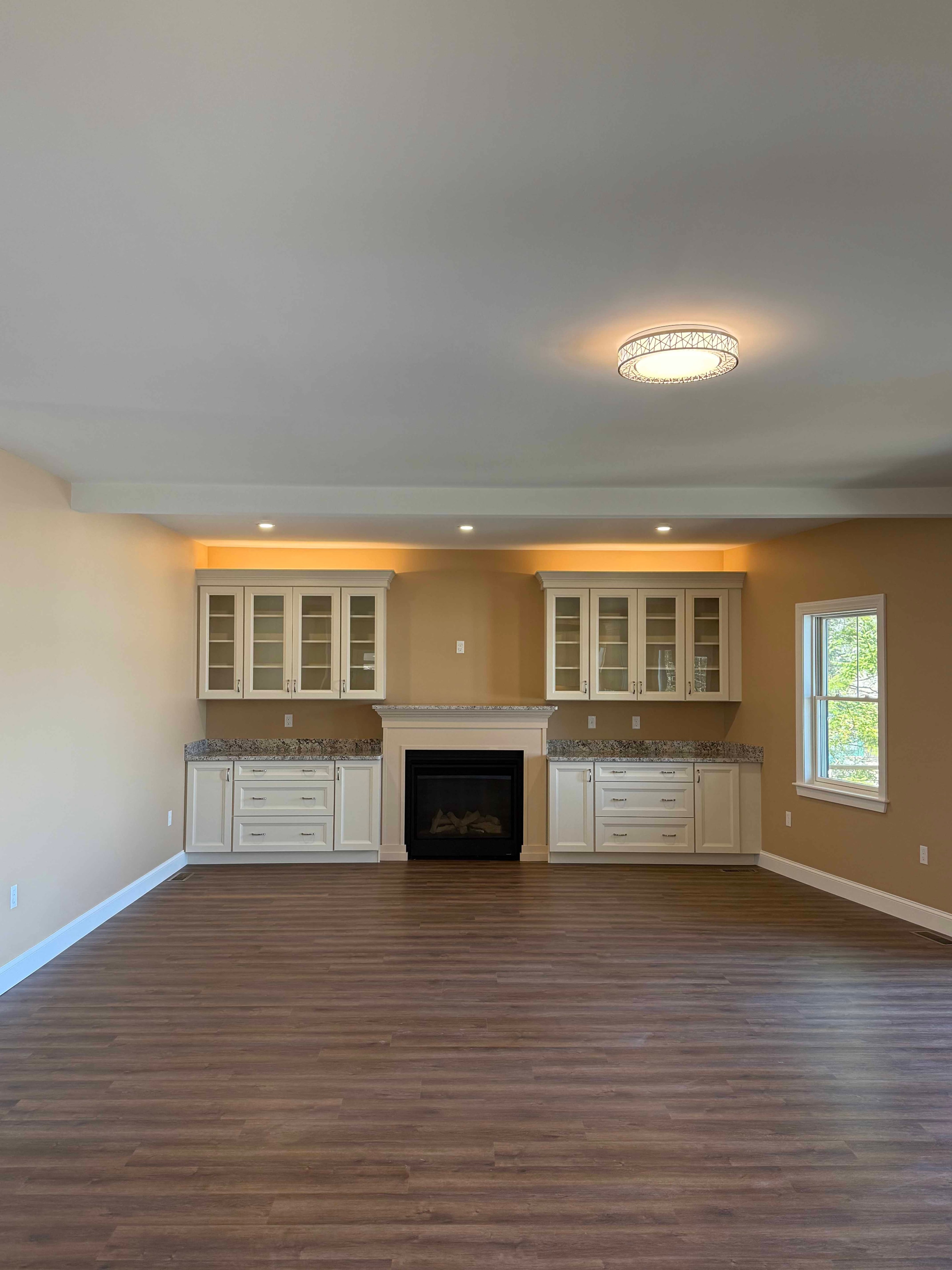 Squam Lake Home great room with two sets of French doors and sweeping frozen lake views
