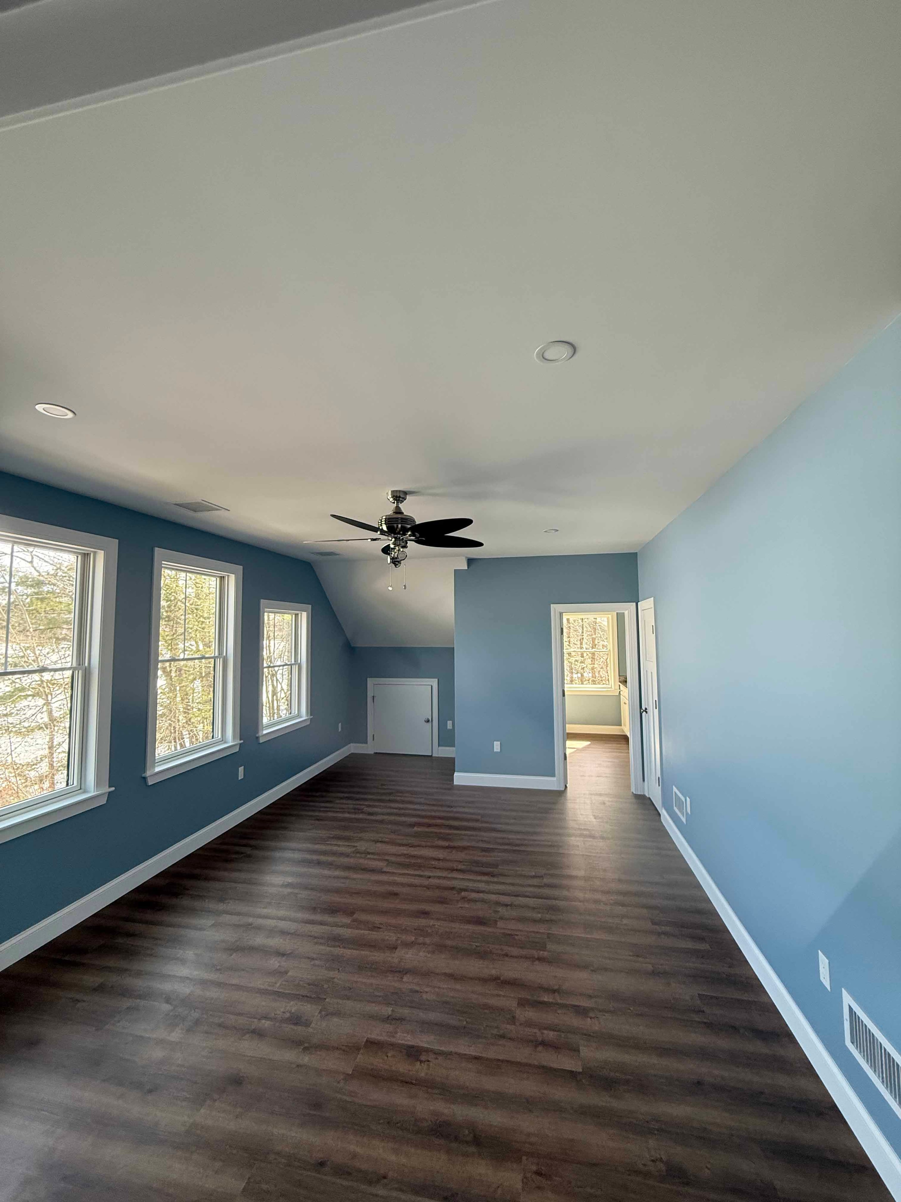Squam Lake Home walk-in shower with large format marble tile, bench, and teal upper walls
