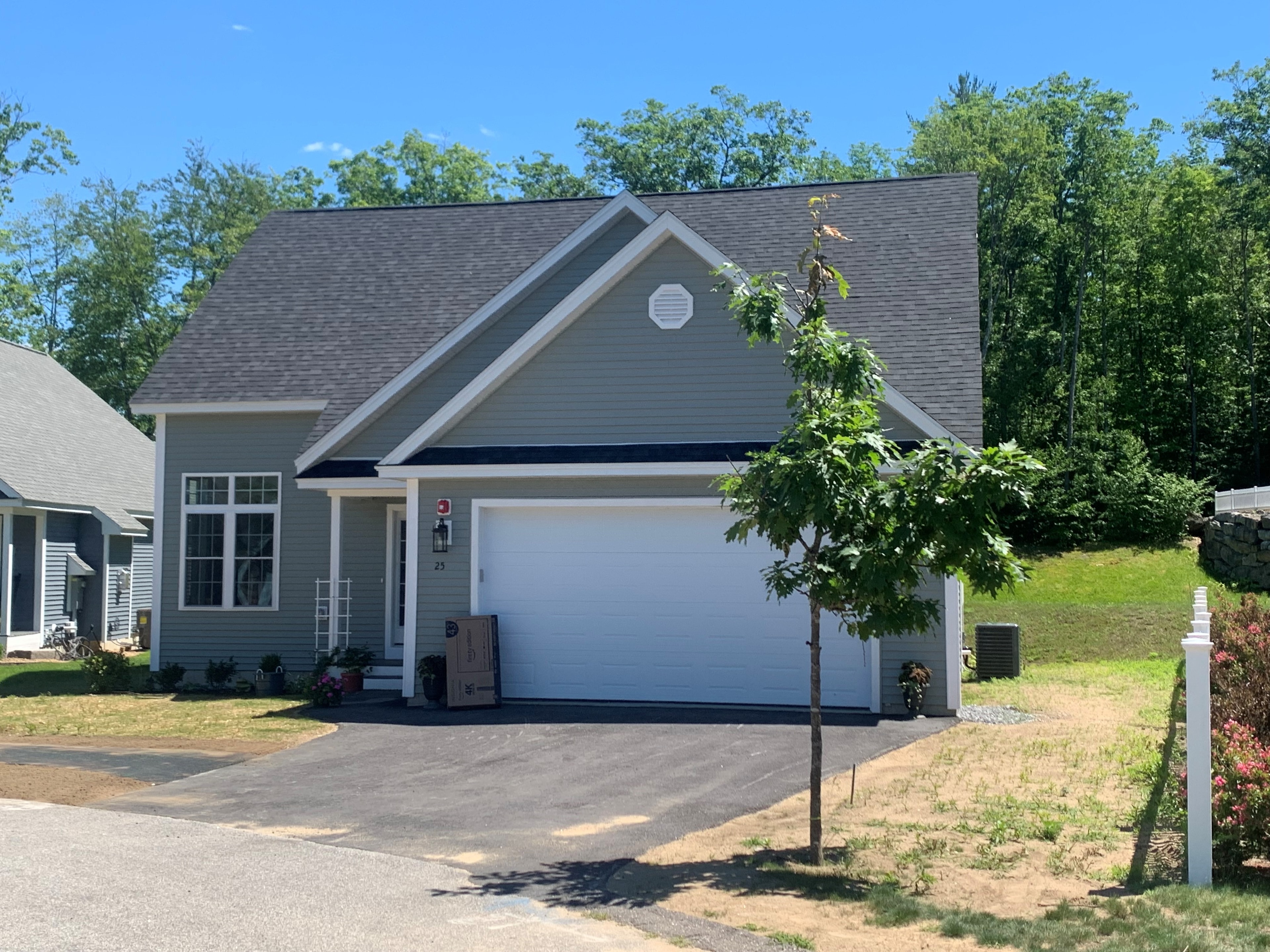 Webster New Build completed sage green exterior with two-car garage, octagon attic vent, and summer landscaping — Governor's Crossing, NH