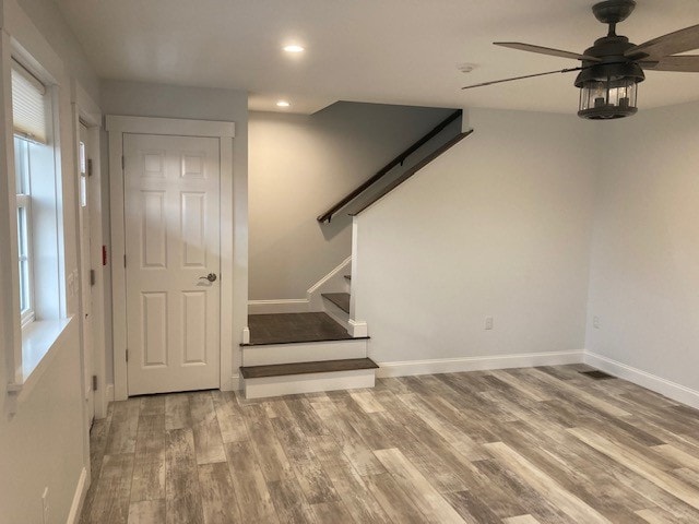 Wentworth New Build living room with open staircase, lantern ceiling fan, and wide-plank wood-look floors — Governor's Crossing, NH
