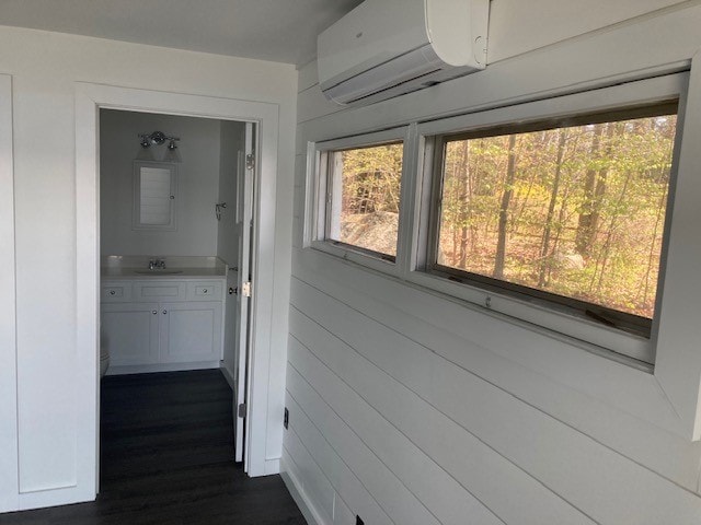 Lake Winnisquam Cottage Remodel sunroom with white shiplap, mini-split, horizontal windows with autumn foliage view, and view into bathroom — Winnisquam, NH
