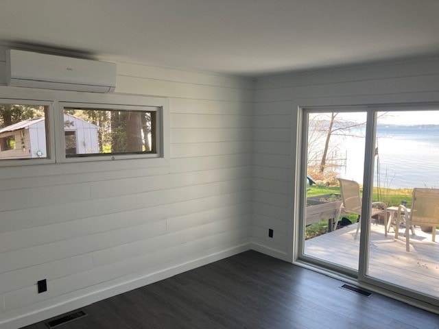 Lake Winnisquam Cottage Remodel sunroom addition with white shiplap walls, mini-split, and sliding glass doors to lake view deck — Winnisquam, NH
